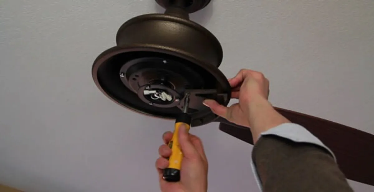 Electrician installing ceiling fan mounting bracket and fixture in Bellevue, WA