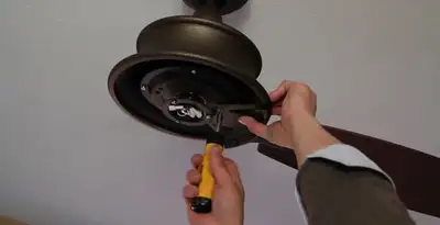 Electrician installing ceiling fan mounting bracket and fixture in Bellevue, WA