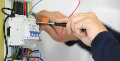 Electrician installing and adjusting circuit breakers in an electrical panel in Bellevue, WA
