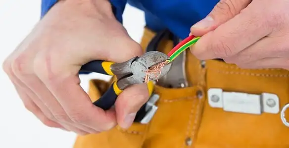 licensed electrician securing electrical wiring with professional tools during service work in Bellevue, WA