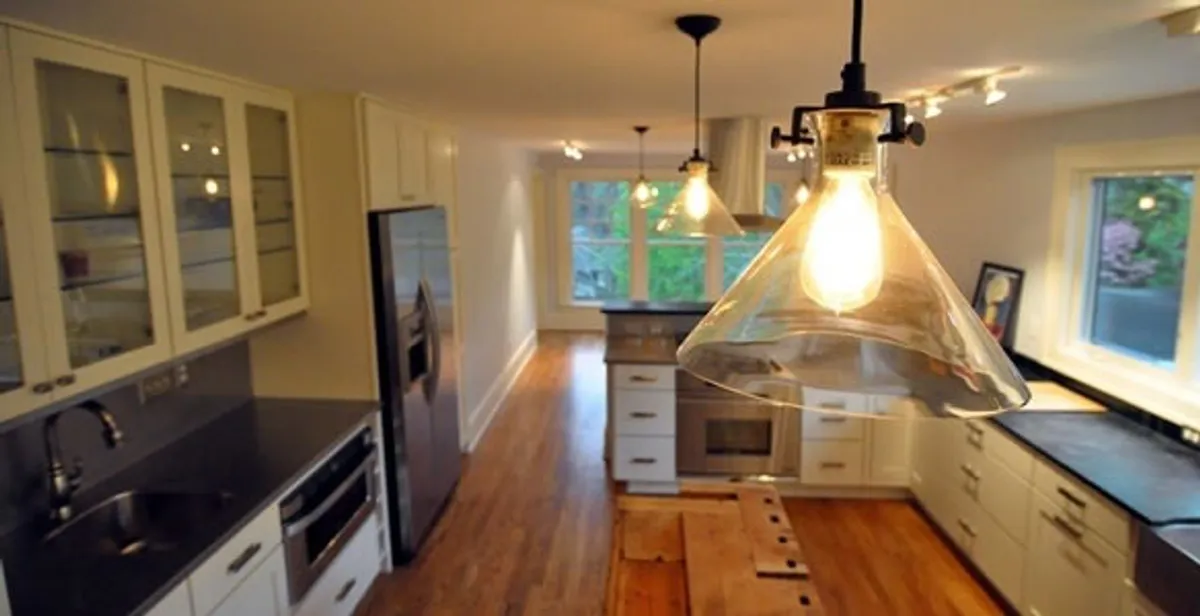 Residential electrician installing modern indoor light fixture in a home in Bellevue, WA
