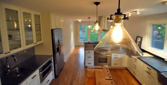 Residential electrician installing modern indoor light fixture in a home in Bellevue, WA