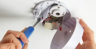 Certified technician wiring smoke detector during installation in Bellevue, WA